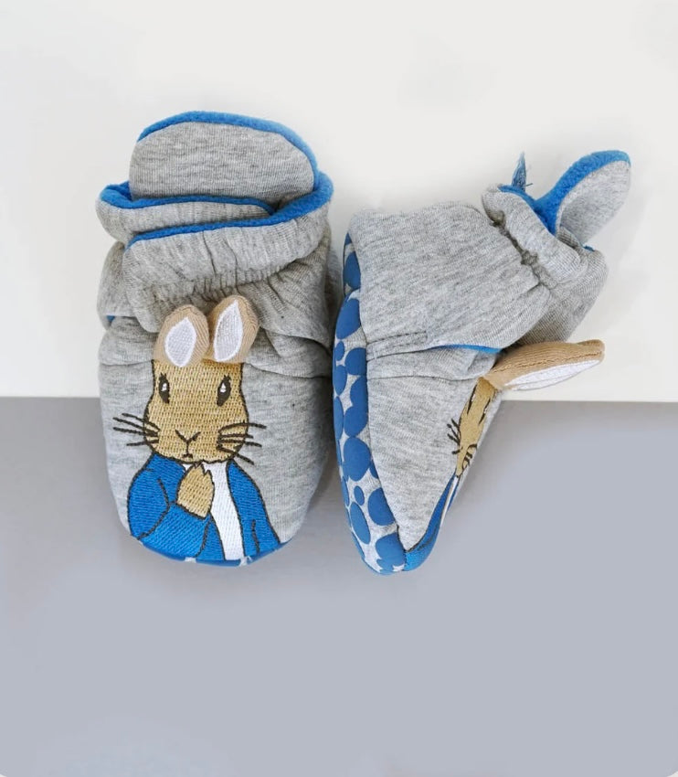 Pair of baby shoes/slippers/booties with Peter Rabbit design on a white background