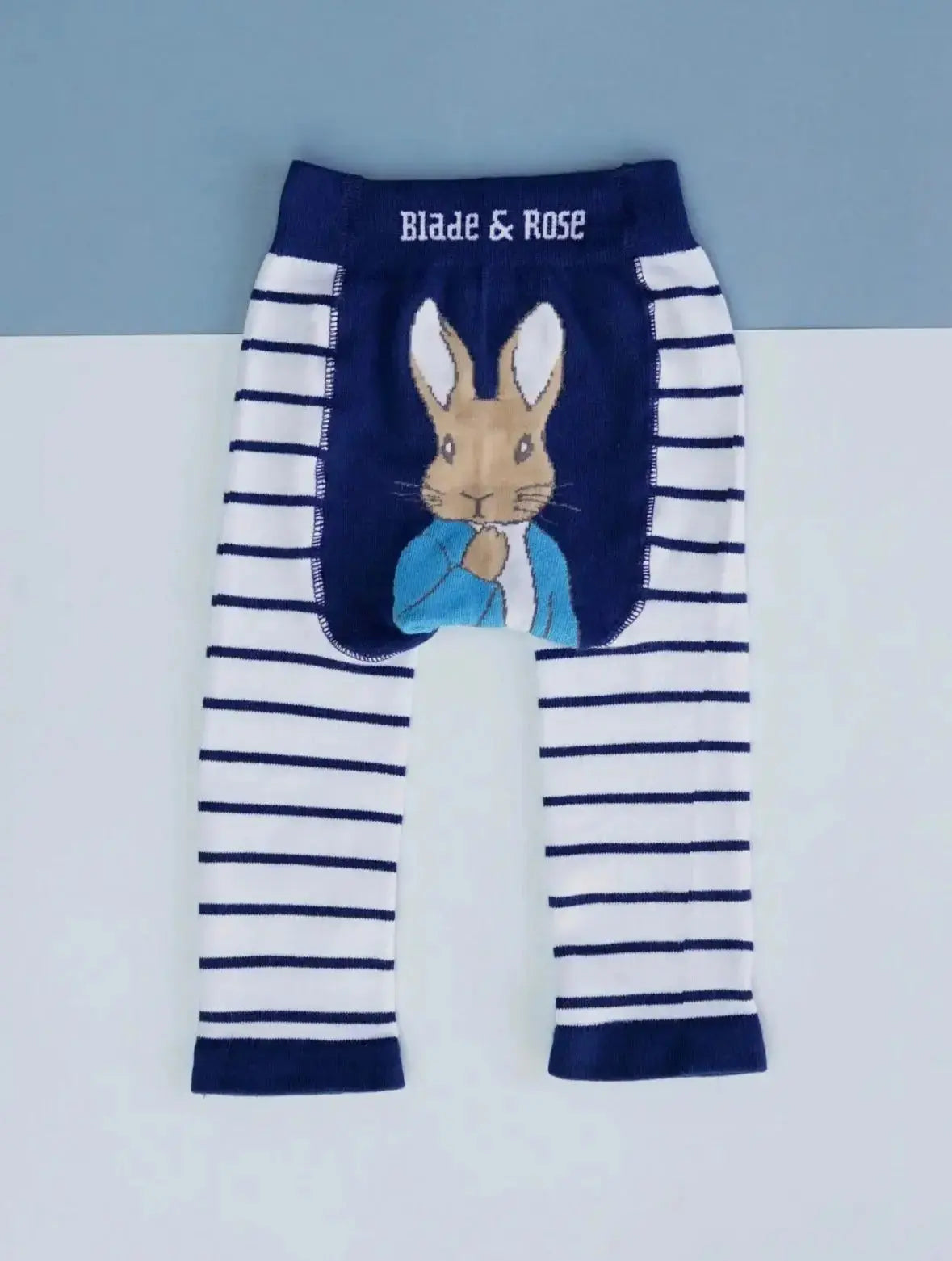 Striped leggings with a Peter Rabbit design on a light gray background